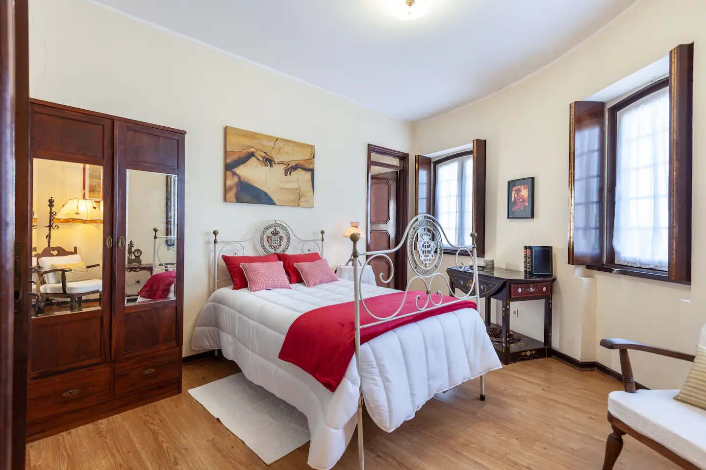 Double bedroom with red textiles and antique furniture