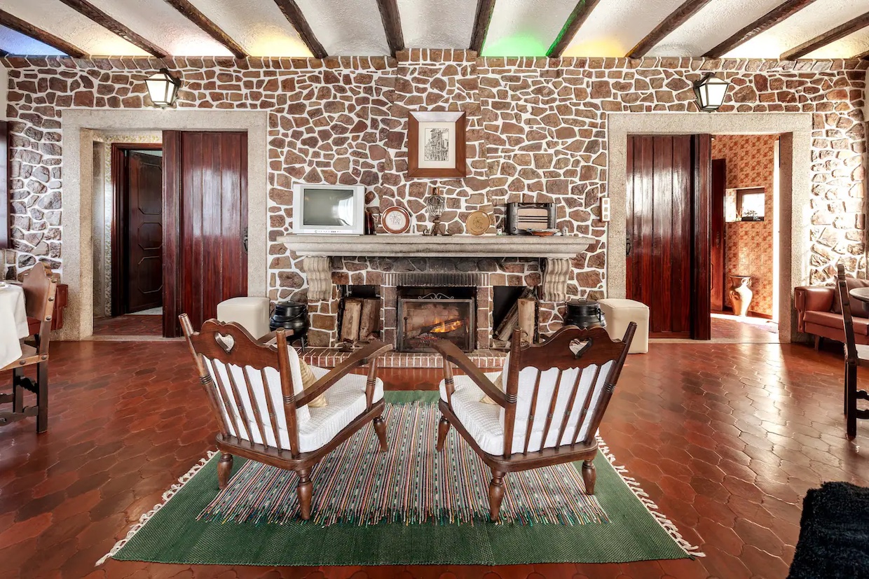 Front view of the original stone fireplace and armchairs
